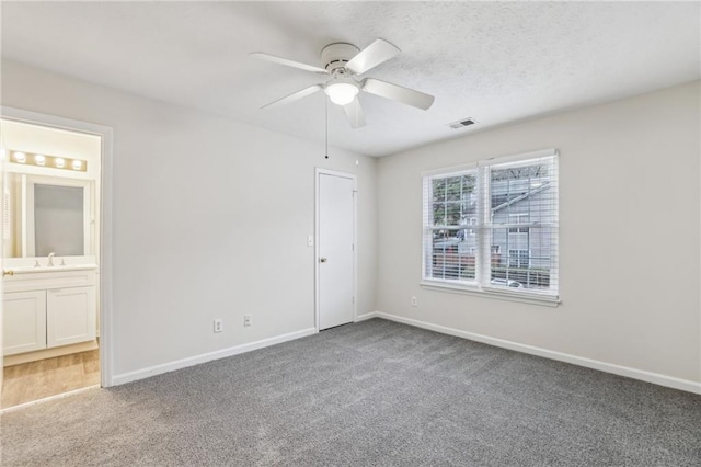 carpeted empty room featuring sink and ceiling fan