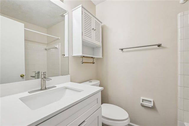 bathroom with tiled shower, toilet, and vanity