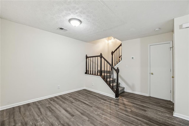 empty room featuring dark wood-type flooring and a textured ceiling