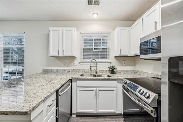 kitchen featuring light stone countertops, sink, white cabinetry, and stainless steel appliances