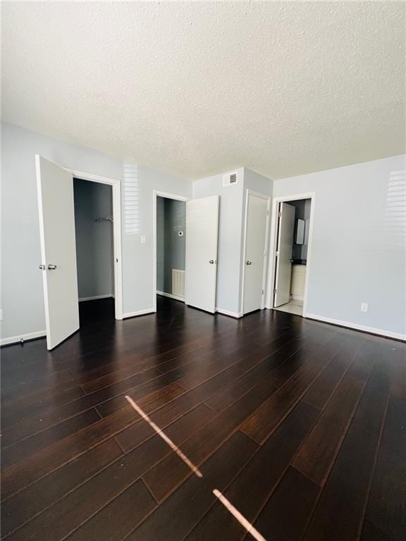 3432 Ivys Walk, Atlanta, GA 30340 - unfurnished bedroom with wood finished floors, baseboards, a textured ceiling, and ensuite bathroom