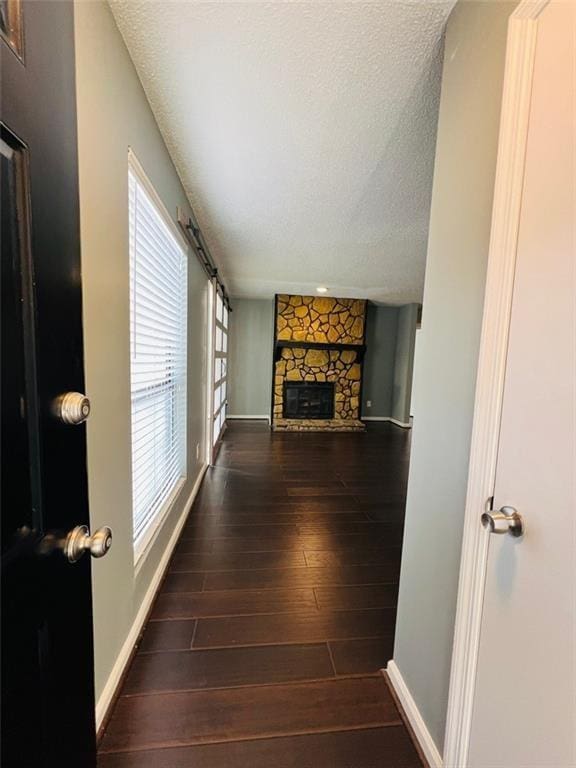 3432 Ivys Walk, Atlanta, GA 30340 - unfurnished living room featuring a textured ceiling, baseboards, wood finished floors, and a fireplace