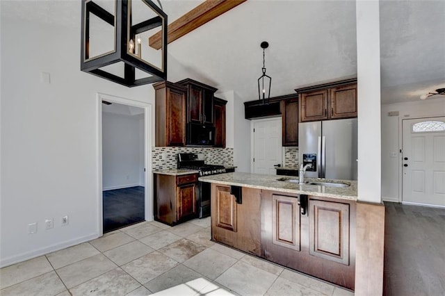 kitchen with a kitchen bar, sink, hanging light fixtures, stainless steel appliances, and backsplash