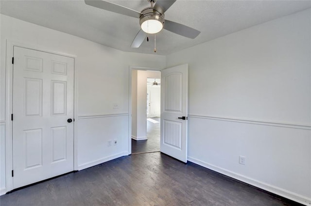 unfurnished bedroom featuring ceiling fan and dark hardwood / wood-style flooring