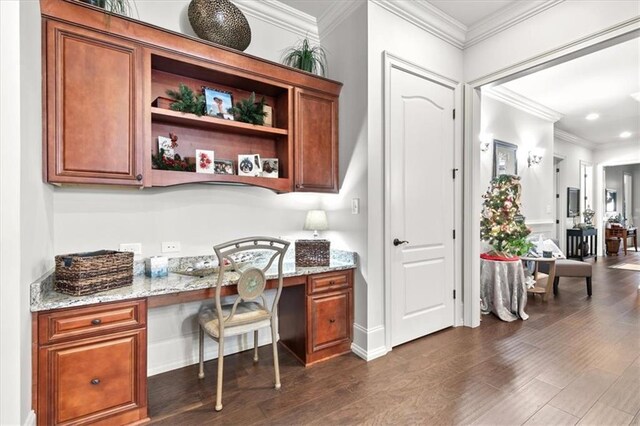 office area with dark hardwood / wood-style floors, built in desk, and crown molding