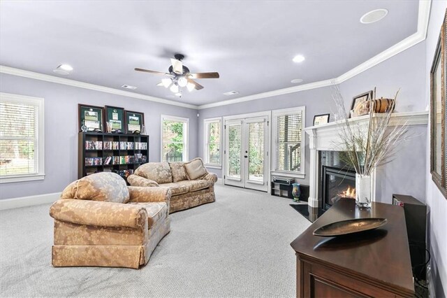 living room with a high end fireplace, carpet floors, plenty of natural light, and crown molding