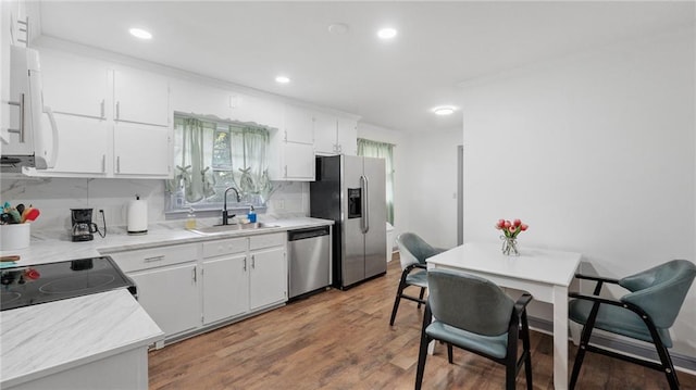 216 Coosawattee Ave SW, Rome, GA 30165 - kitchen with stainless steel appliances, a sink, wood finished floors, white cabinets, and light countertops