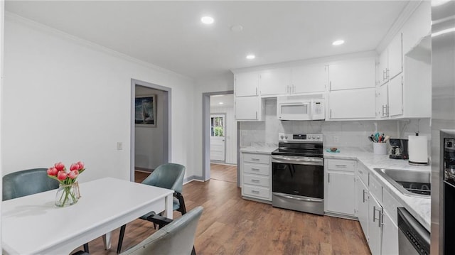 216 Coosawattee Ave SW, Rome, GA 30165 - kitchen featuring appliances with stainless steel finishes, a sink, ornamental molding, white cabinetry, and decorative backsplash