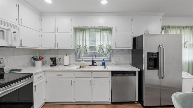 216 Coosawattee Ave SW, Rome, GA 30165 - kitchen featuring stainless steel appliances, a sink, white cabinetry, light countertops, and ornamental molding