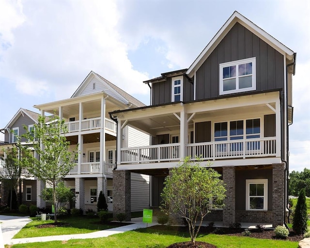 1415 Coretta Bnd, Atlanta, GA 30318 - view of front of house with board and batten siding, brick siding, a front yard, and a balcony