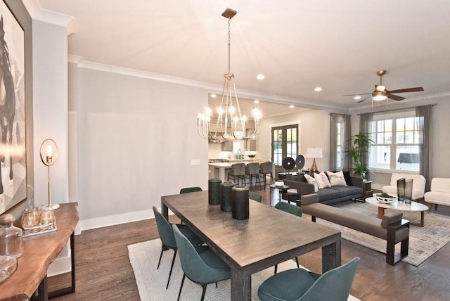dining area featuring dark wood-style flooring, ceiling fan with notable chandelier, recessed lighting, baseboards, and ornamental molding