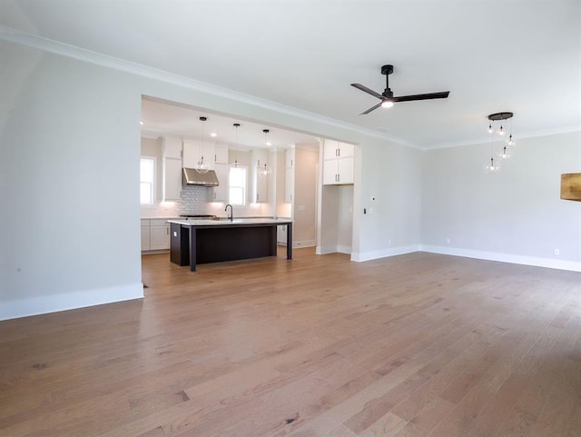 1415 Coretta Bnd, Atlanta, GA 30318 - unfurnished living room with crown molding, ceiling fan, light wood-style floors, baseboards, and a sink