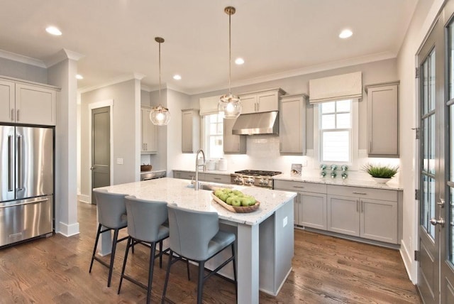 kitchen featuring a sink, appliances with stainless steel finishes, under cabinet range hood, and a wealth of natural light