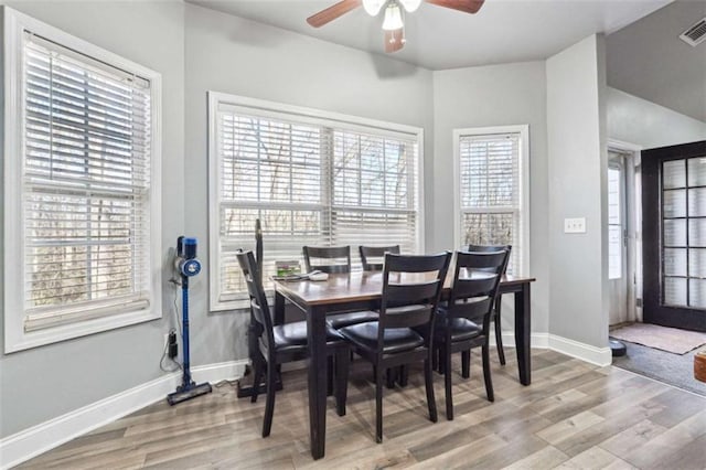 dining area with light wood finished floors, visible vents, baseboards, and a ceiling fan