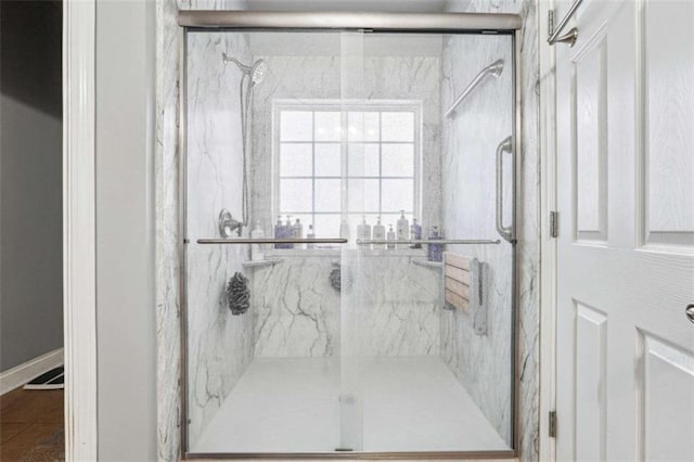 bathroom featuring a marble finish shower