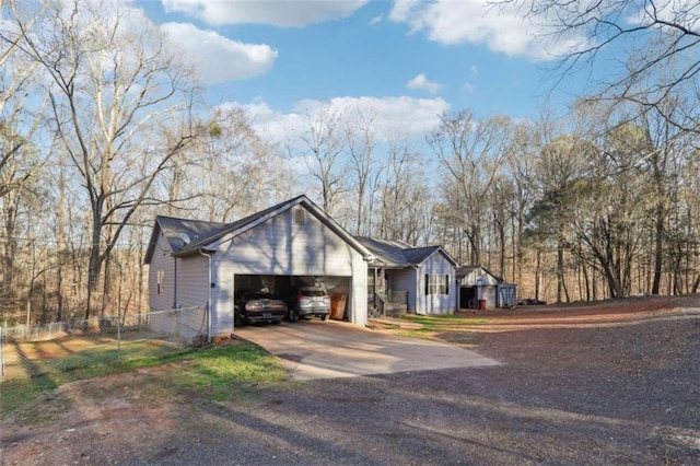 view of front of property with a garage, concrete driveway, and fence