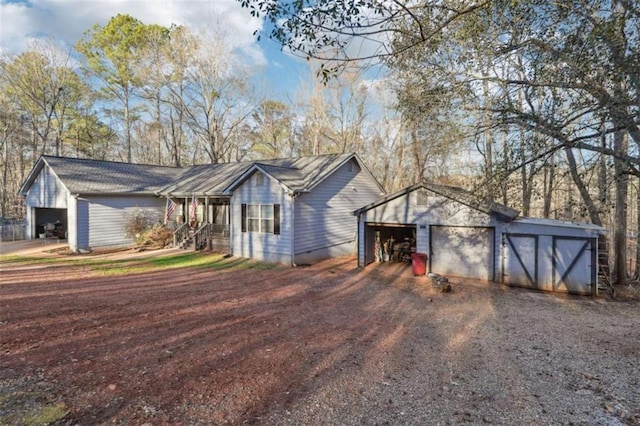 ranch-style house featuring a detached garage and an outbuilding