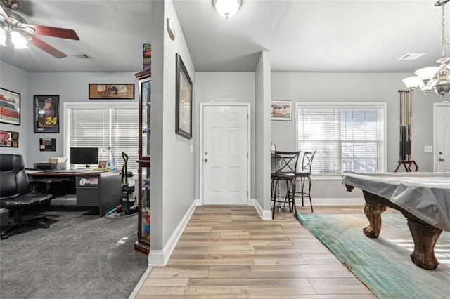 interior space featuring ceiling fan with notable chandelier, pool table, visible vents, baseboards, and light wood-type flooring