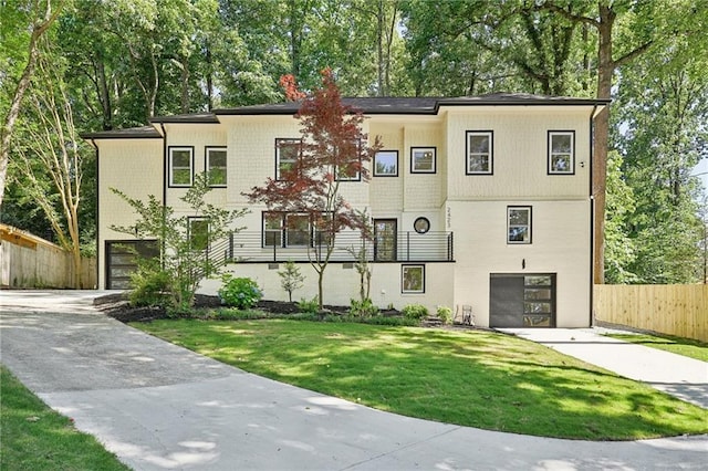 view of property featuring a garage, a front yard, driveway, and fence