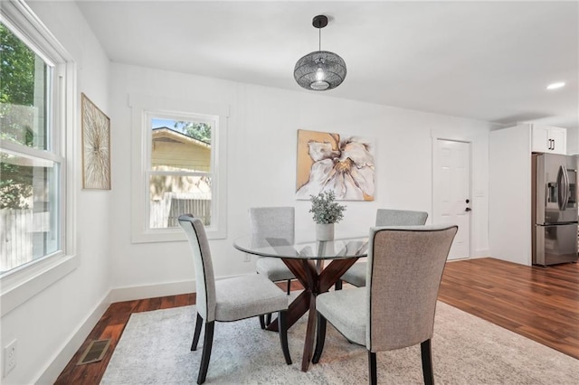 dining area featuring visible vents, baseboards, and dark wood-style floors