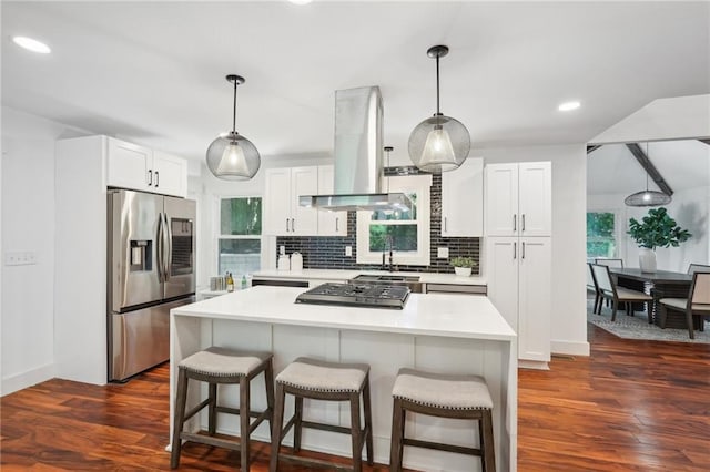 kitchen with a kitchen breakfast bar, stainless steel fridge, backsplash, and island range hood