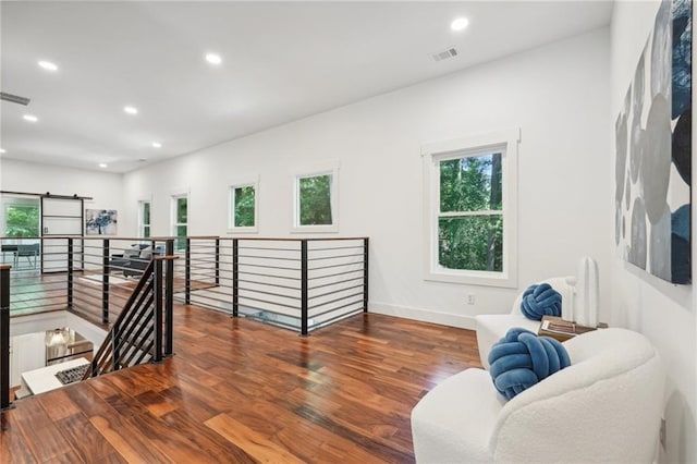 living area featuring visible vents, baseboards, an upstairs landing, recessed lighting, and wood finished floors