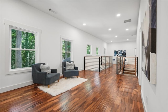 living area with an upstairs landing, visible vents, recessed lighting, and wood-type flooring