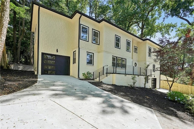 view of property with concrete driveway and fence