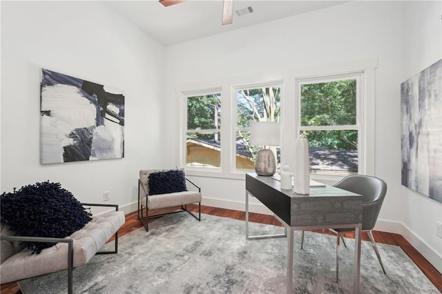 office space with visible vents, ceiling fan, baseboards, and wood finished floors