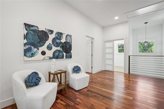 living area with attic access, recessed lighting, wood finished floors, and baseboards