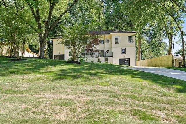 exterior space with a garage, concrete driveway, and fence