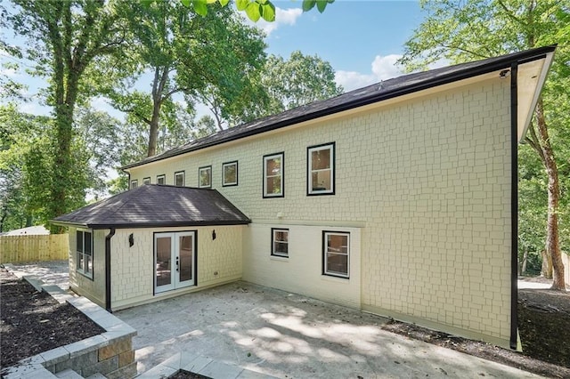 rear view of property featuring french doors, a patio area, and fence