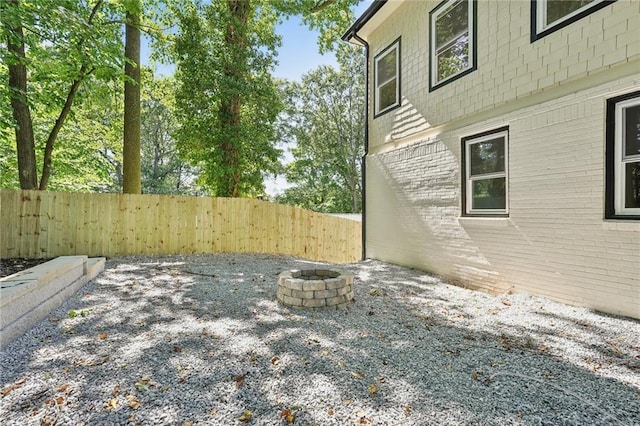 view of yard featuring fence and an outdoor fire pit