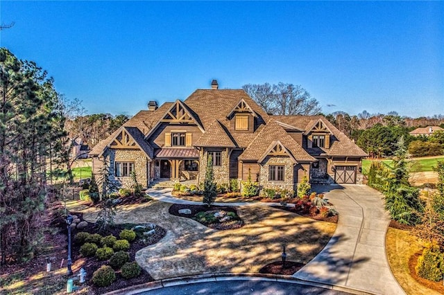 260 Traditions Dr, Alpharetta, GA 30004 - tudor home featuring concrete driveway, stone siding, a chimney, a garage, and a porch