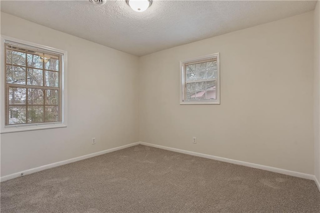 carpeted empty room featuring a textured ceiling