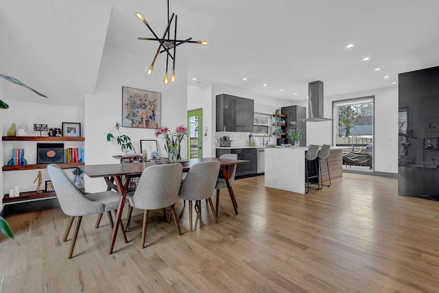 dining room with a chandelier, light wood finished floors, and recessed lighting