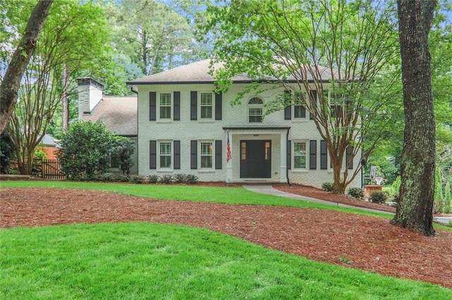 3323 Lancing Ct, Duluth, GA 30096 - colonial house with brick siding, a chimney, and a front lawn