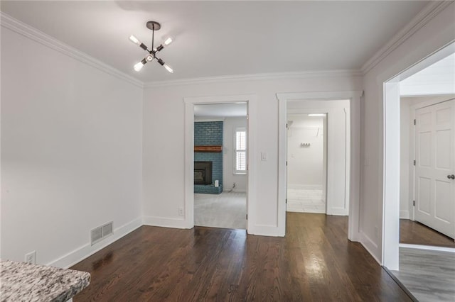 3323 Lancing Ct, Duluth, GA 30096 - unfurnished living room featuring a chandelier, baseboards, dark wood-style floors, crown molding, and a brick fireplace