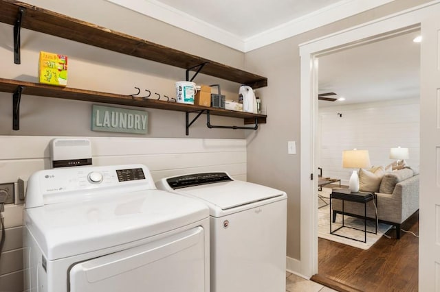 laundry room with laundry area, wood finished floors, independent washer and dryer, and ornamental molding