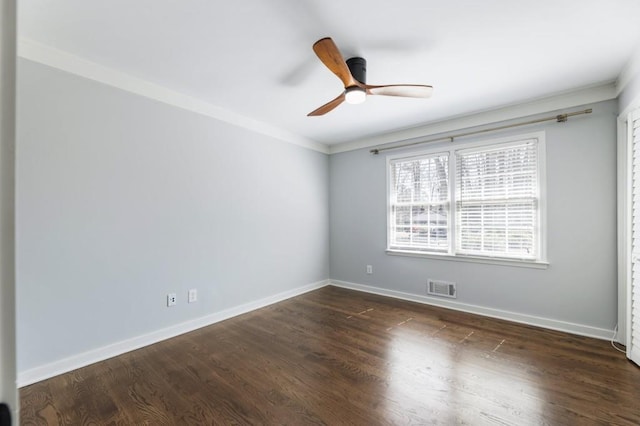 unfurnished room featuring dark wood finished floors, visible vents, a ceiling fan, and baseboards