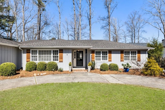 single story home with a front yard, board and batten siding, and driveway