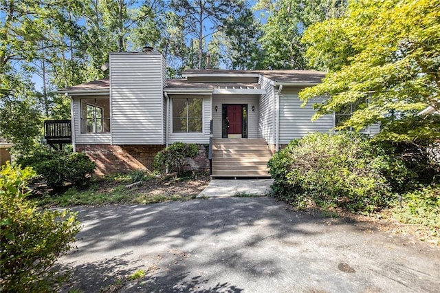 view of front of house featuring a chimney and brick siding