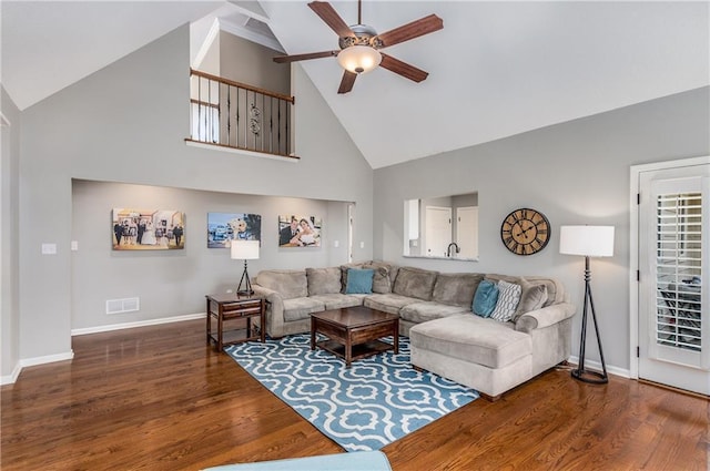 living room featuring a ceiling fan, visible vents, baseboards, and wood finished floors