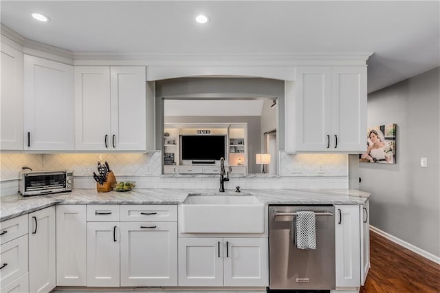 kitchen with baseboards, white cabinets, dark wood-type flooring, stainless steel dishwasher, and a sink