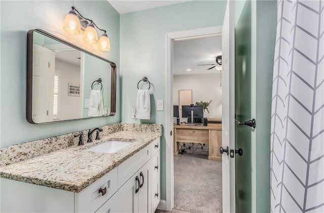 ensuite bathroom with a ceiling fan, vanity, and ensuite bath