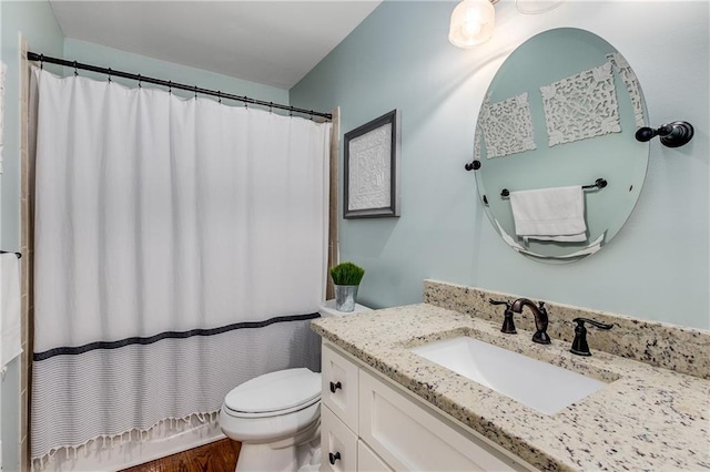 full bathroom with curtained shower, vanity, and toilet