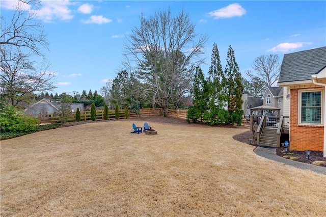 view of yard featuring fence, a deck, and stairs