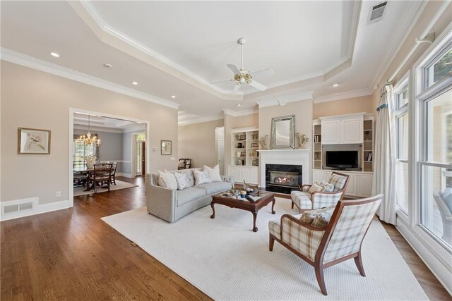 4790 Hyde Rd, Cumming, GA 30040 - living room with dark wood-style flooring, crown molding, visible vents, and a raised ceiling