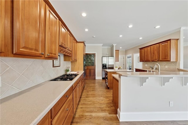 4790 Hyde Rd, Cumming, GA 30040 - kitchen with recessed lighting, stainless steel fridge with ice dispenser, ornamental molding, gas cooktop, and a breakfast bar area