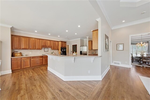4790 Hyde Rd, Cumming, GA 30040 - kitchen featuring brown cabinets, light wood-style flooring, a breakfast bar area, light countertops, and stainless steel refrigerator with ice dispenser